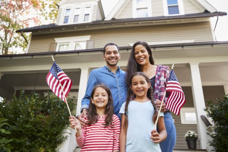 Family with kids waving american flags